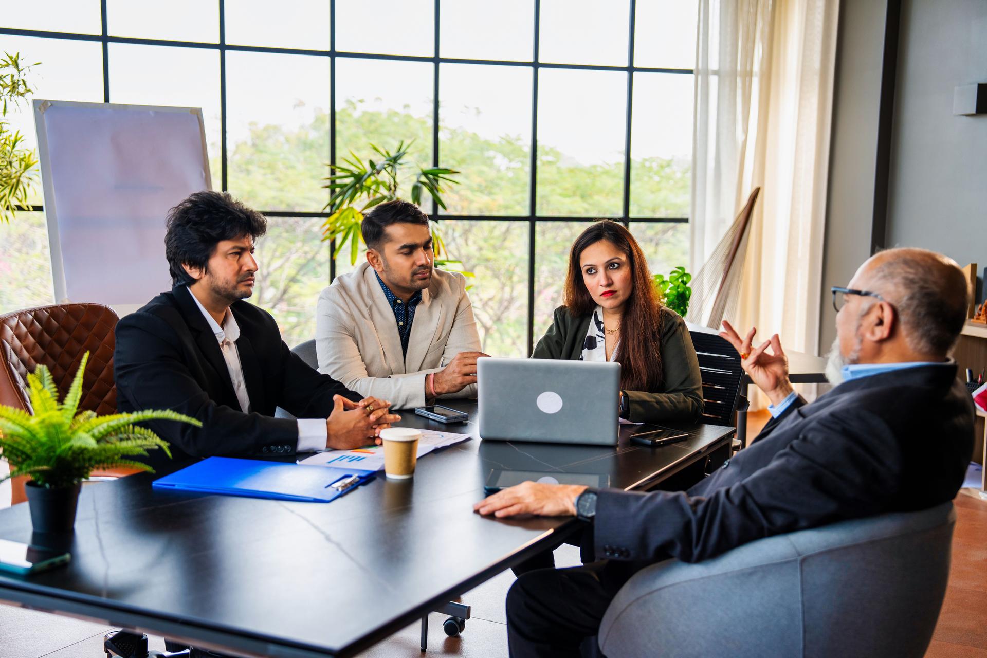 Indian asian Corporate team brainstorming business strategies in a conference room meeting